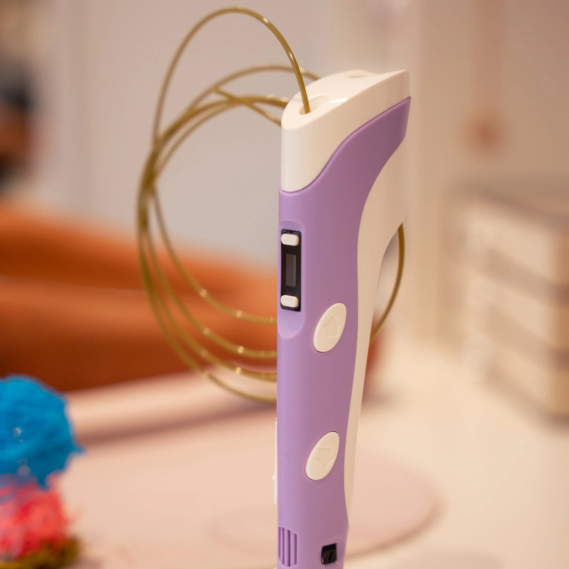 Lilla og hvid 3D pen med filament i hjemmemiljø, kreative værktøjer.